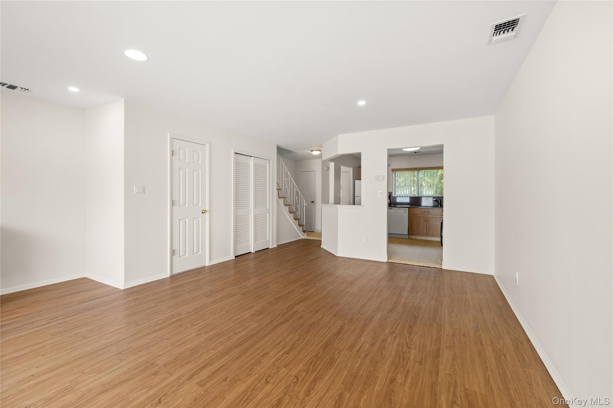 650 Newbridge Road, Unit 15 East Meadow, NY 11554 - Photo 5 of 20 a view of empty room with wooden floor and kitchen