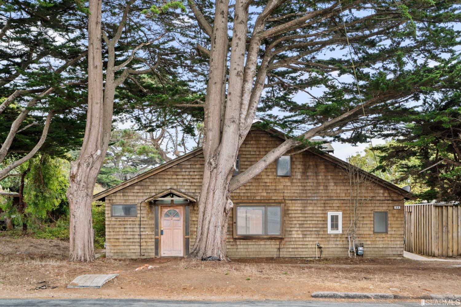 a front view of a house with a tree