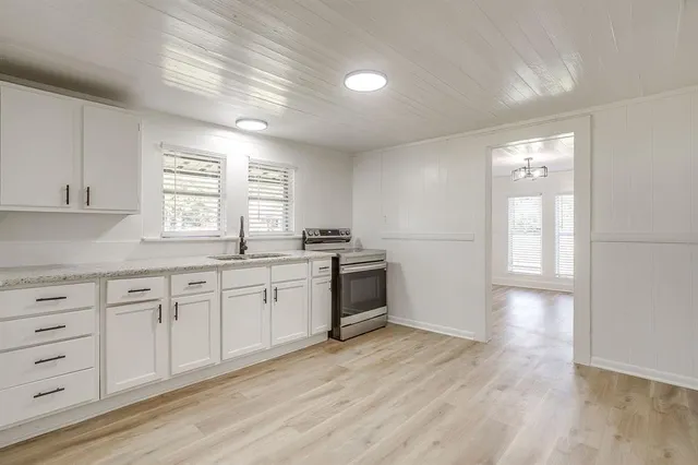 a kitchen with granite countertop white cabinets and white appliances
