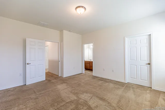 an empty room with closet area and bathroom