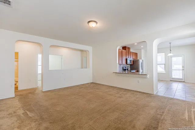 an empty room with windows and cabinet