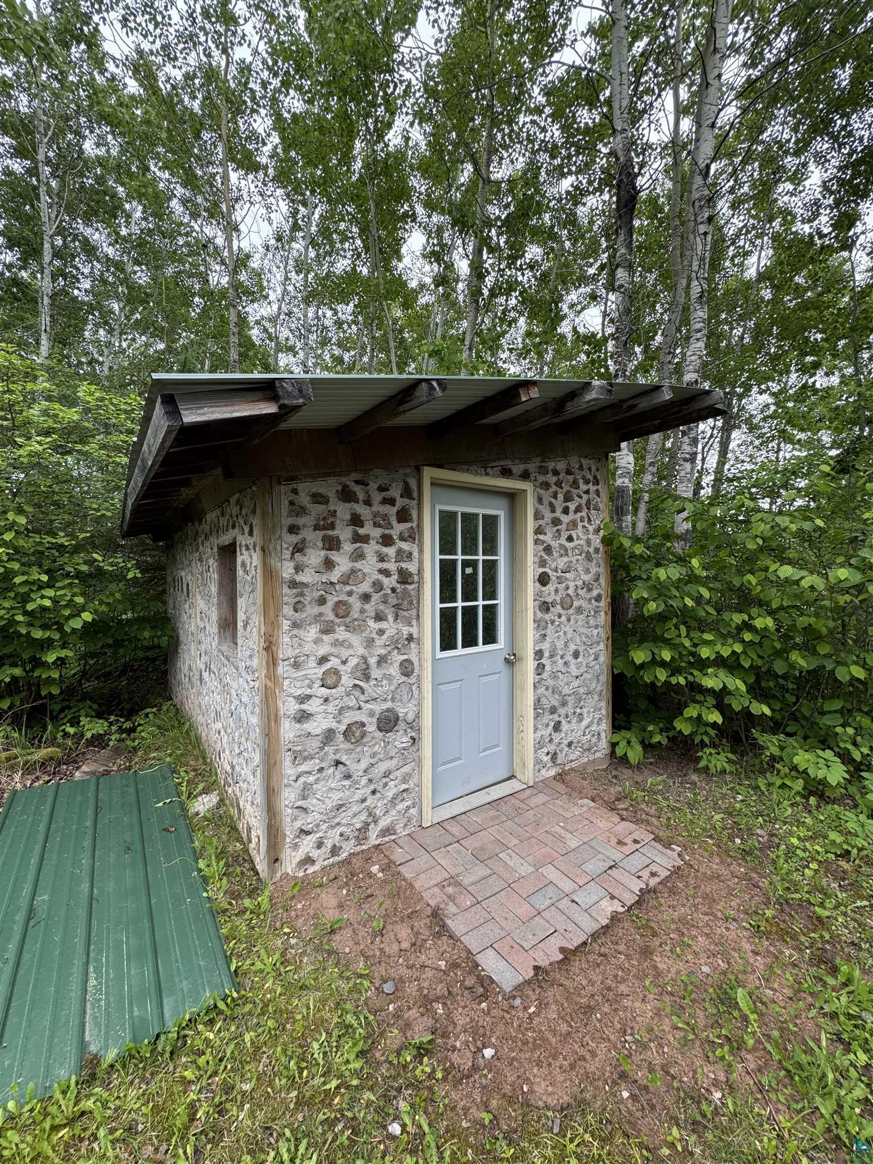 1745 Becks Road Maple, WI 54854 - Photo 39 of 46 Stone-clad structure with a light gray paneled door and small window