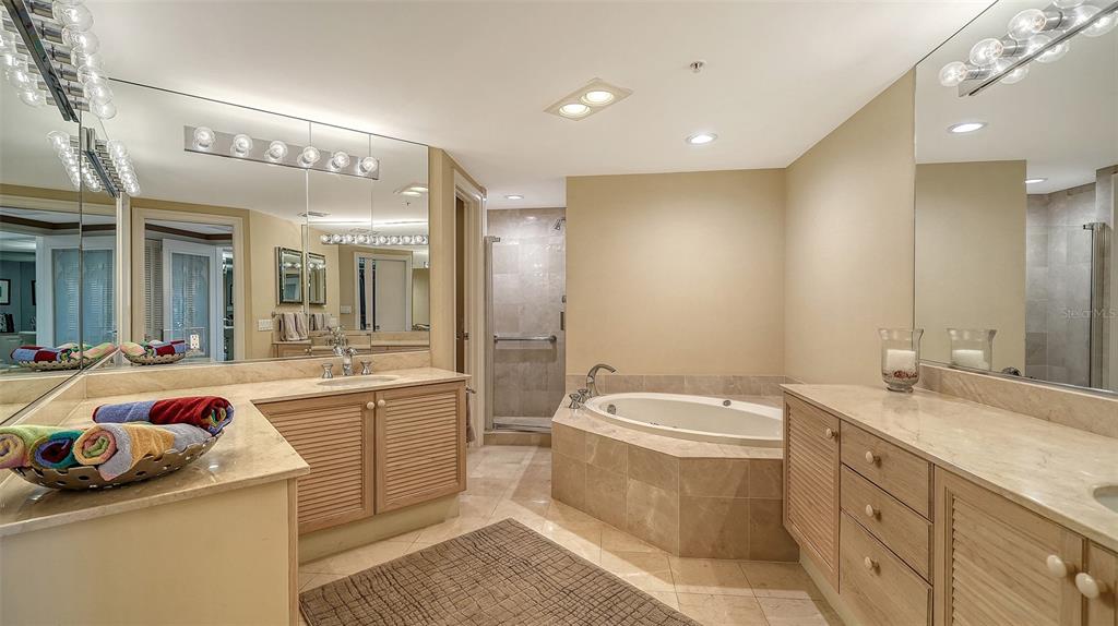 545 Sanctuary Drive, Unit B506 Longboat Key, FL 34228 - Photo 16 of 53 a bathroom with a double vanity sink a mirror and a bathtub