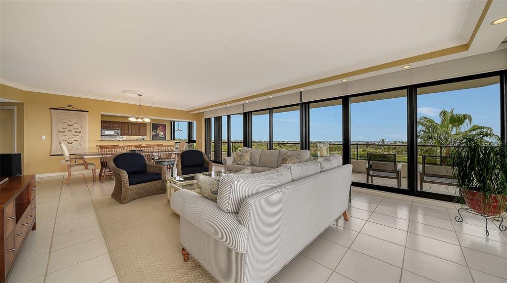545 Sanctuary Drive, Unit B506 Longboat Key, FL 34228 - Photo 8 of 53 a living room with furniture a floor to ceiling window and flat screen tv