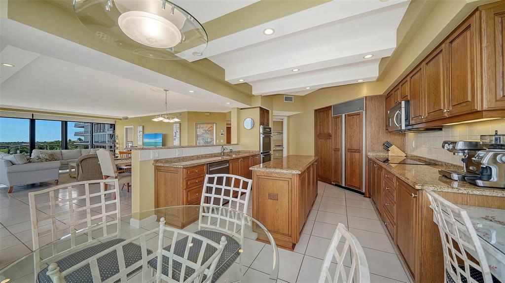 545 Sanctuary Drive, Unit B506 Longboat Key, FL 34228 - Photo 10 of 53 a kitchen with stainless steel appliances granite countertop a refrigerator a stove top oven and a dining table with wooden floors