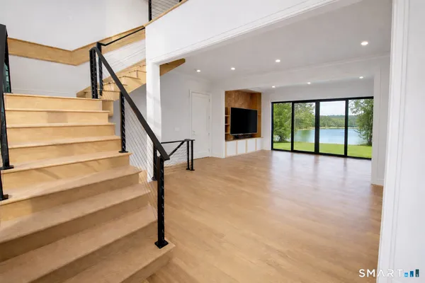 a view of staircase with a floor to ceiling window and wooden floor