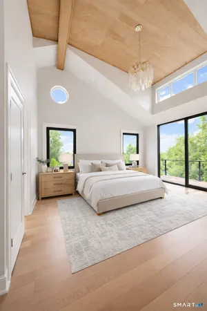 a bedroom with a large bed and a chandelier fan