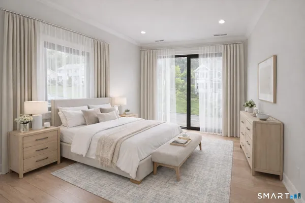 a bedroom with a balcony a bed and a large window