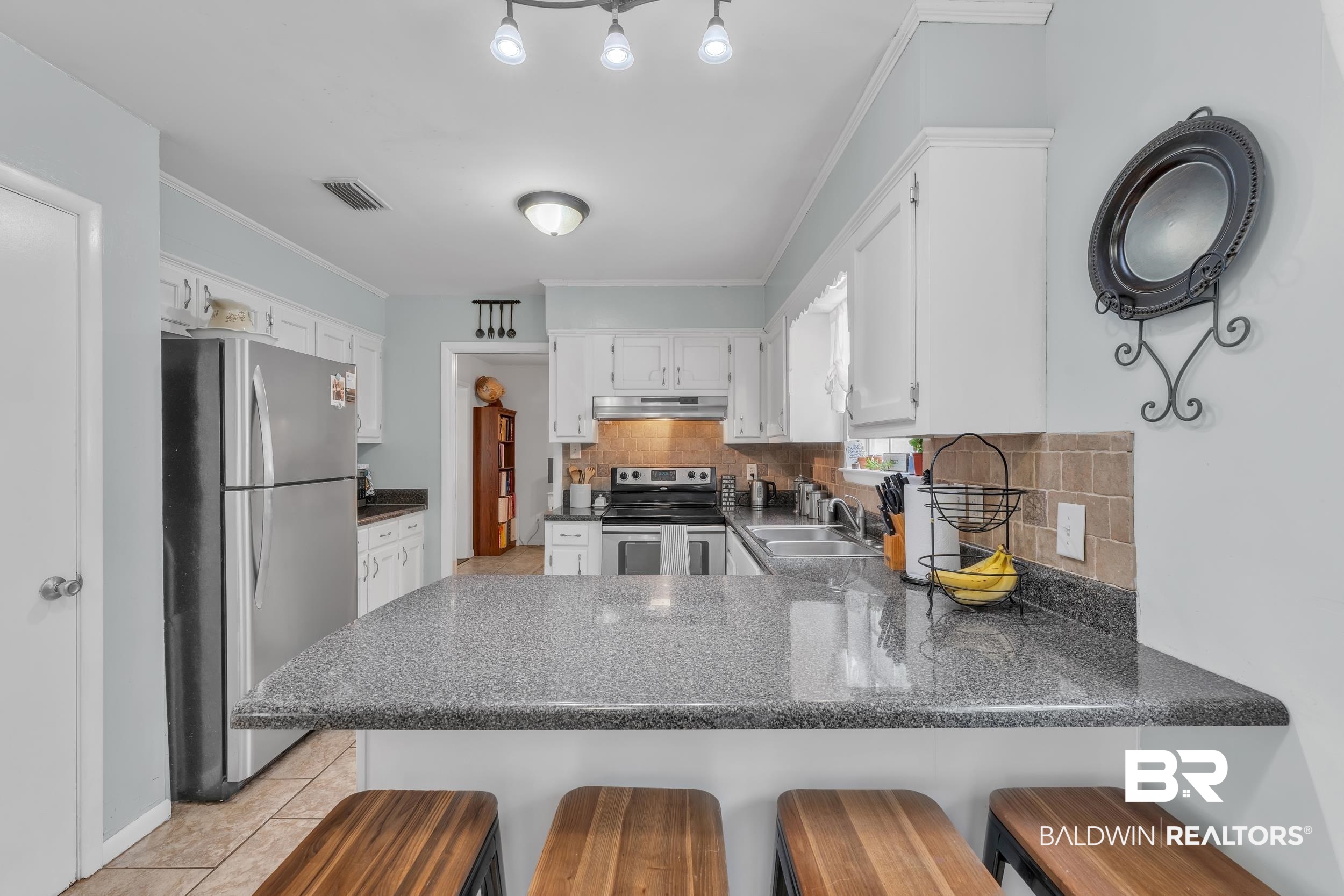 224 Cache Circle Mobile, AL 36611 - Photo 10 of 42 Kitchen featuring appliances with stainless steel finishes, under cabinet range hood, a peninsula, a sink, and white cabinets