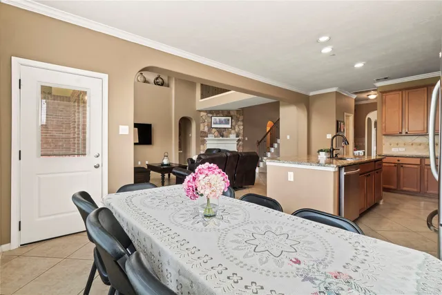 a kitchen with a dining table chairs and refrigerator