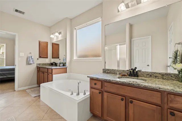 a spacious bathroom with a granite countertop sink mirror and bathtub