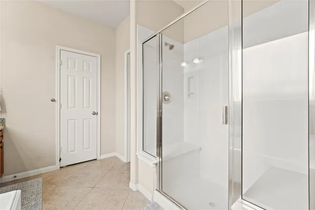 a bathroom with a shower and a glass door