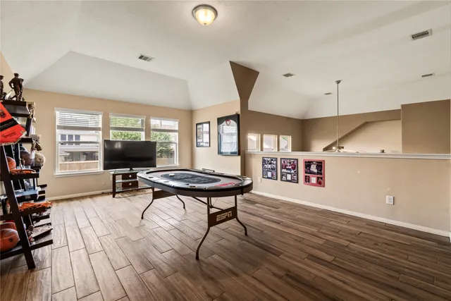 a living room with furniture a flat screen tv and a wooden floor