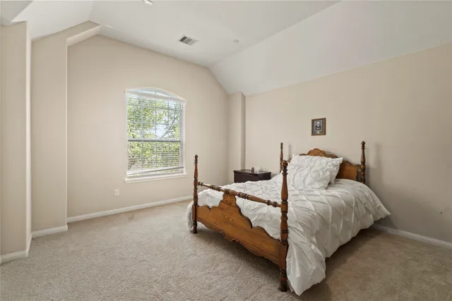 a bed sitting in a bedroom next to a window
