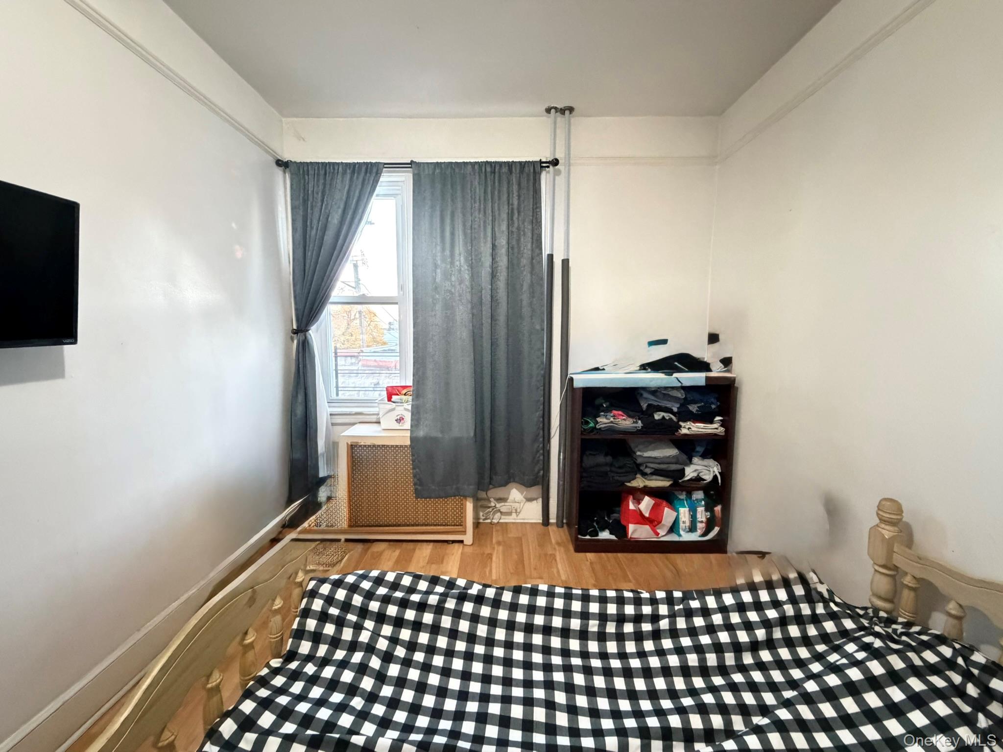 111-20 14th Road Queens, NY 11356 - Photo 11 of 13 a bedroom with a bed and a window