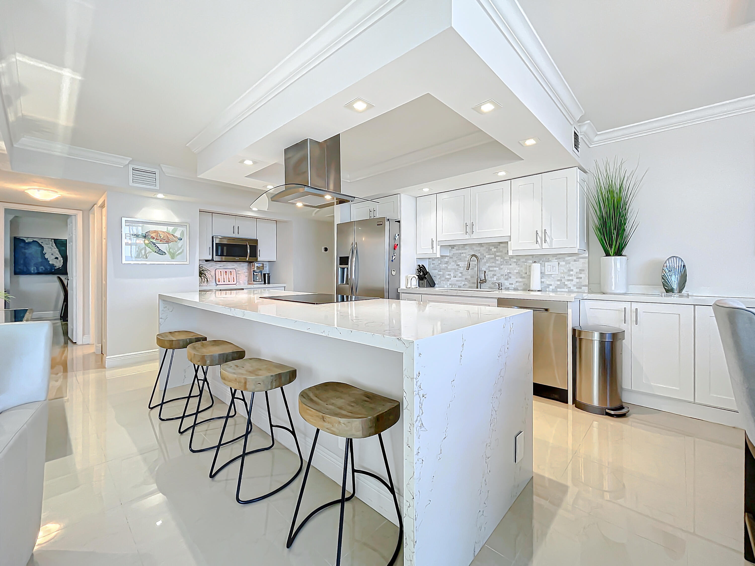 a kitchen with stainless steel appliances kitchen island a table chairs sink and cabinets