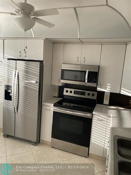 a kitchen with stainless steel appliances kitchen island a stove and a refrigerator