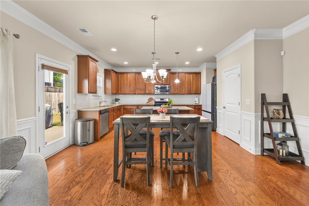 874 Wild Orchard Lane Woodruff, SC 29388 - Photo 3 of 35 This open concept kitchen and dining area features rich wood flooring and modern appliances.