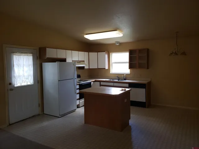 a kitchen with stainless steel appliances granite countertop a refrigerator a sink a stove a microwave a counter space and cabinets