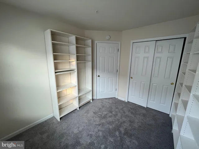 a view of an empty room with cabinet and door