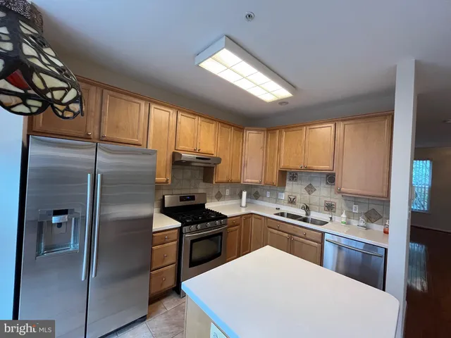 a kitchen with a refrigerator a sink a stove and cabinets