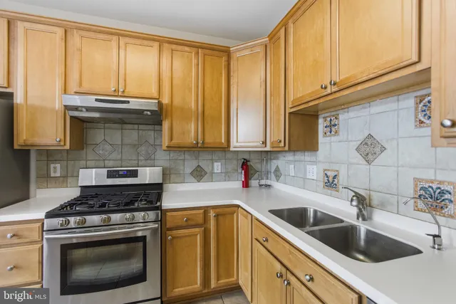 a kitchen with stainless steel appliances granite countertop a sink stove and cabinets