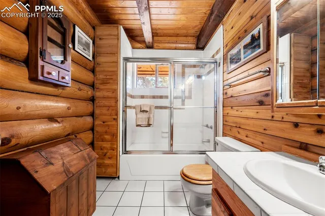 a bedroom with furniture a flat screen tv and a window