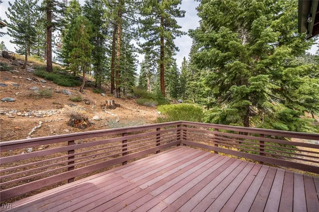 a view of deck house and trees in the background