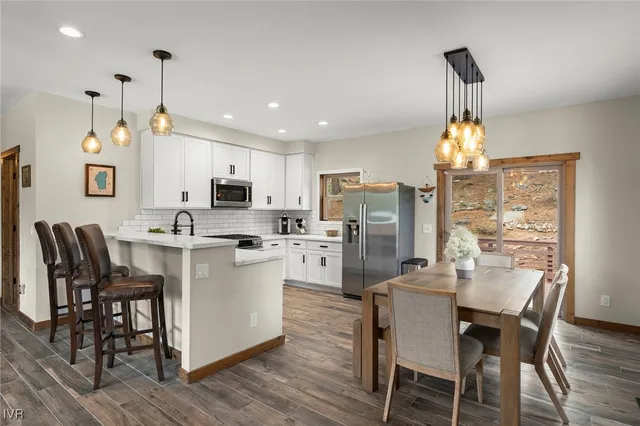 a kitchen with refrigerator a sink and chairs