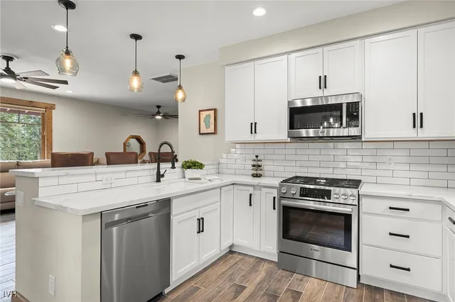 a kitchen with appliances a sink and cabinets