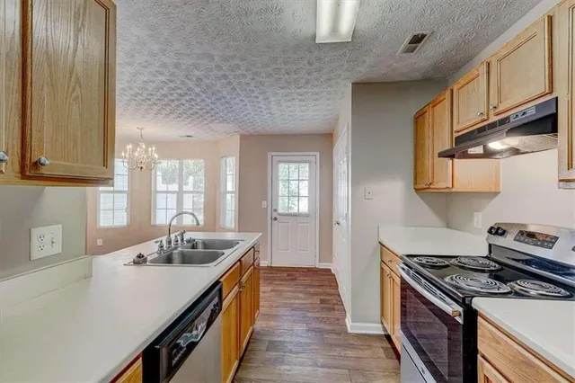 a kitchen with stainless steel appliances a sink stove and cabinets