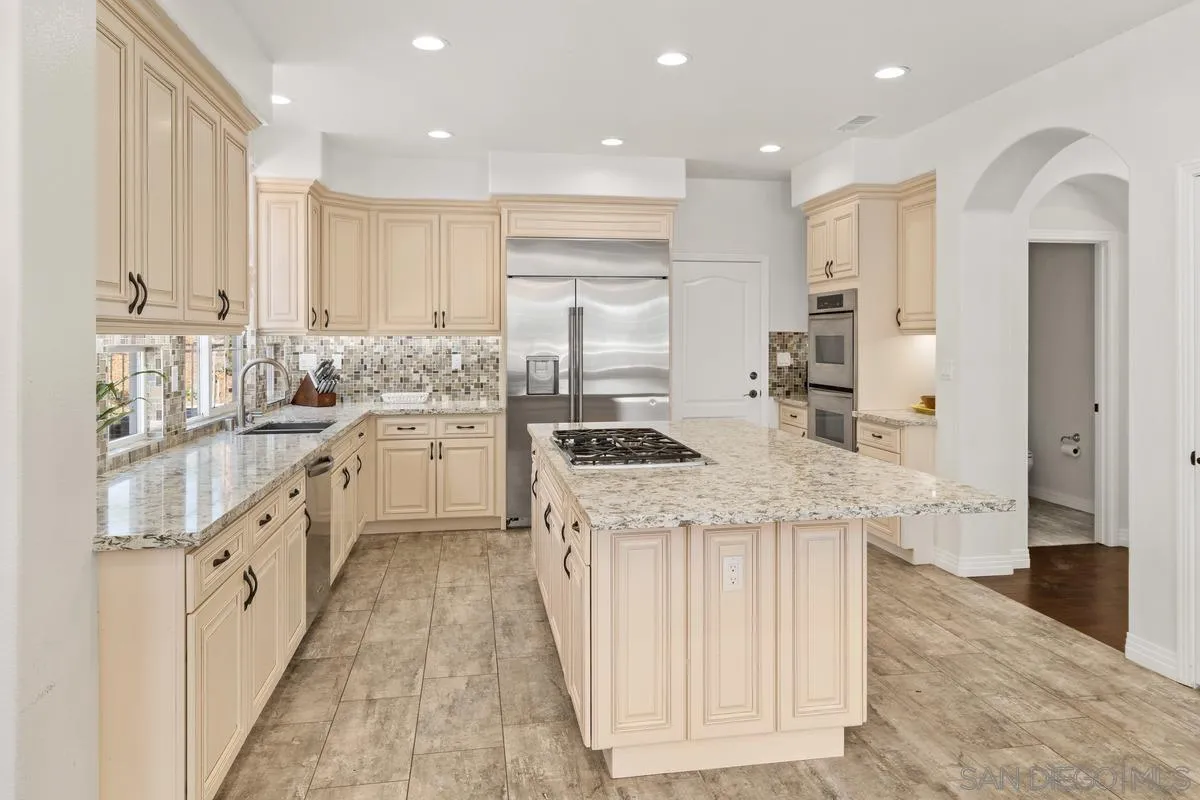 13630 Ash Hollow Crossing Road Poway, CA 92064 - Photo 13 of 55 a kitchen with stainless steel appliances granite countertop a stove a sink and a refrigerator