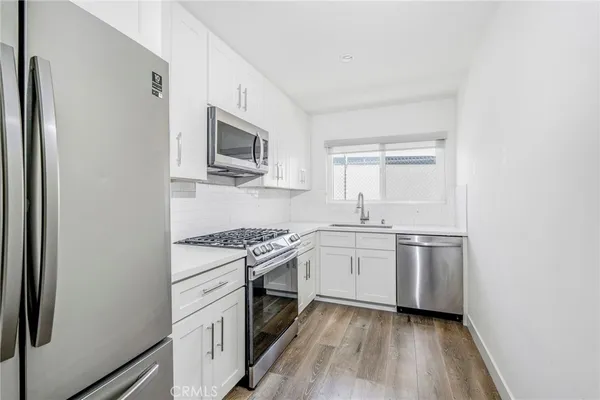 a metallic refrigerator freezer sitting in a kitchen