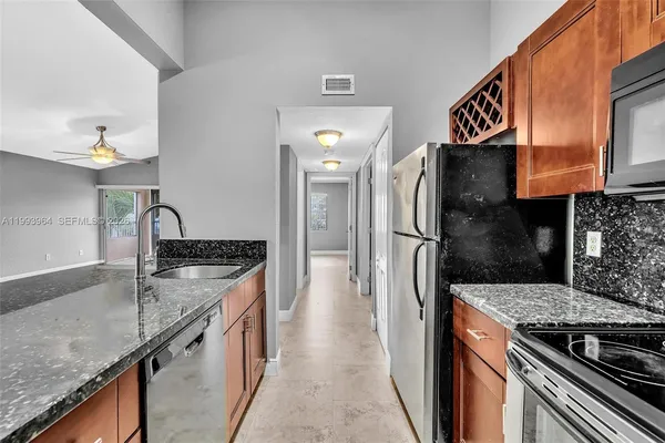 a kitchen with stainless steel appliances granite countertop a sink stove and refrigerator