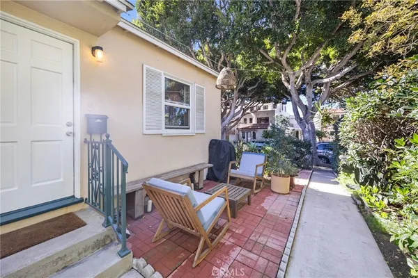 a view of a patio with a dining table and chairs with wooden floor and fence