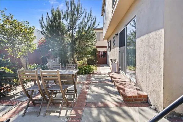 a view of a patio with table and chairs and potted plants
