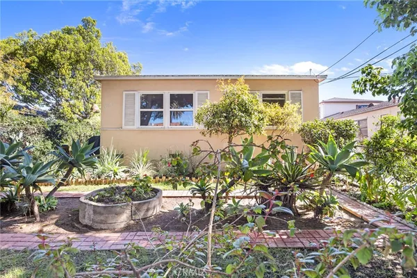 a front view of a house with a garden