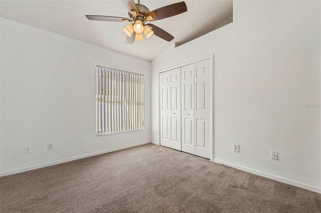 2627 Oneida Loop Kissimmee, FL 34747 - Photo 20 of 32 an empty room with windows and fan