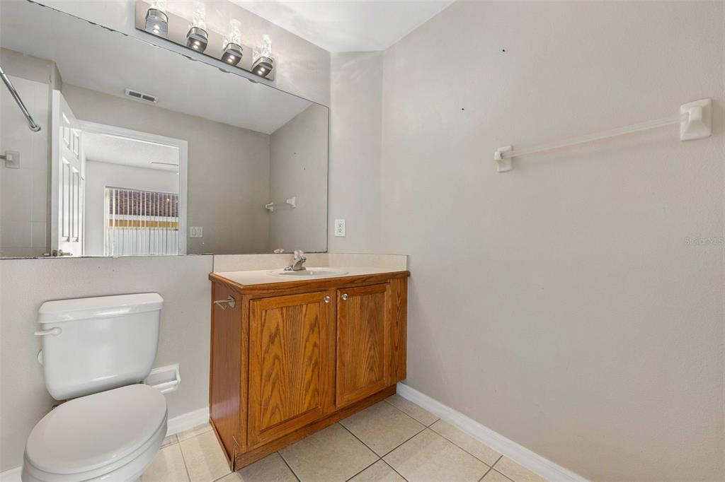 2627 Oneida Loop Kissimmee, FL 34747 - Photo 22 of 32 a bathroom with a toilet sink and mirror
