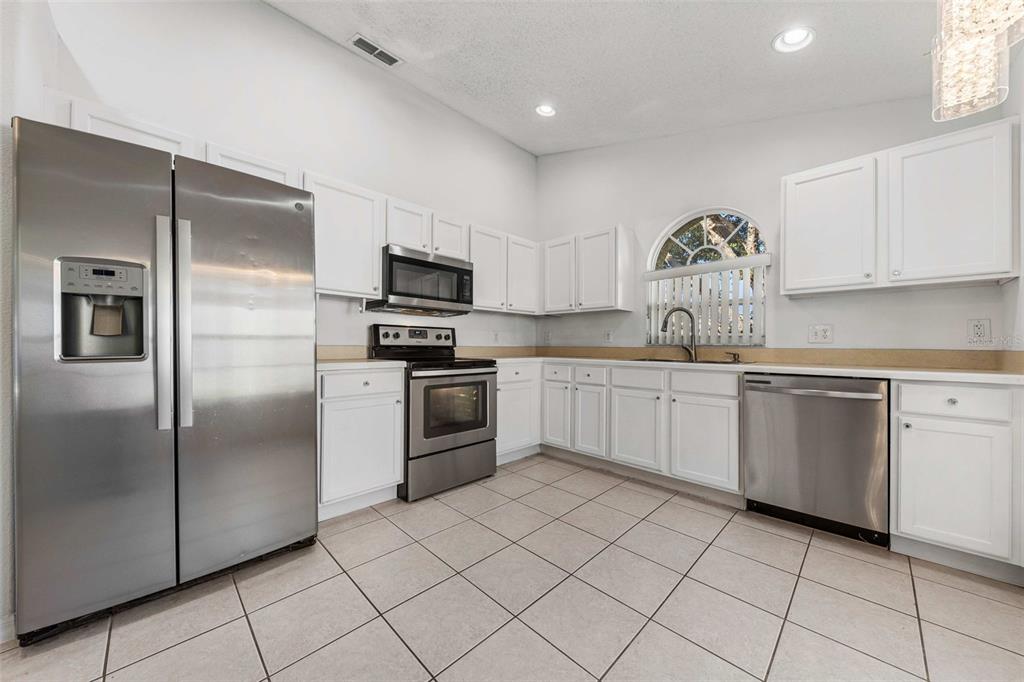 2627 Oneida Loop Kissimmee, FL 34747 - Photo 6 of 32 a kitchen with a sink appliances and cabinets