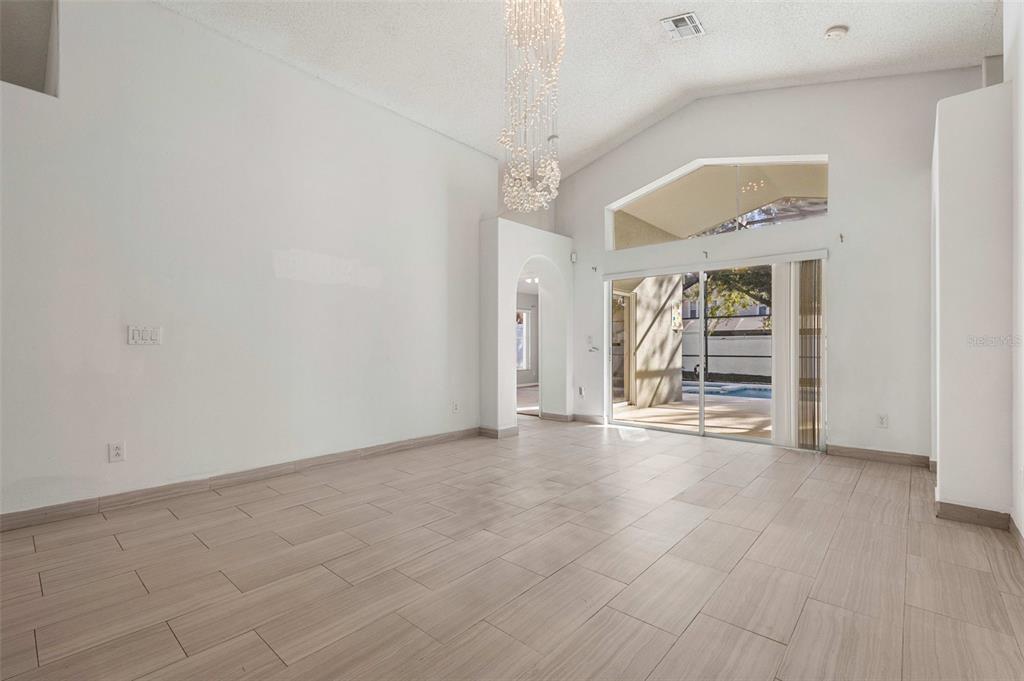2627 Oneida Loop Kissimmee, FL 34747 - Photo 9 of 32 an empty room with wooden floor and windows