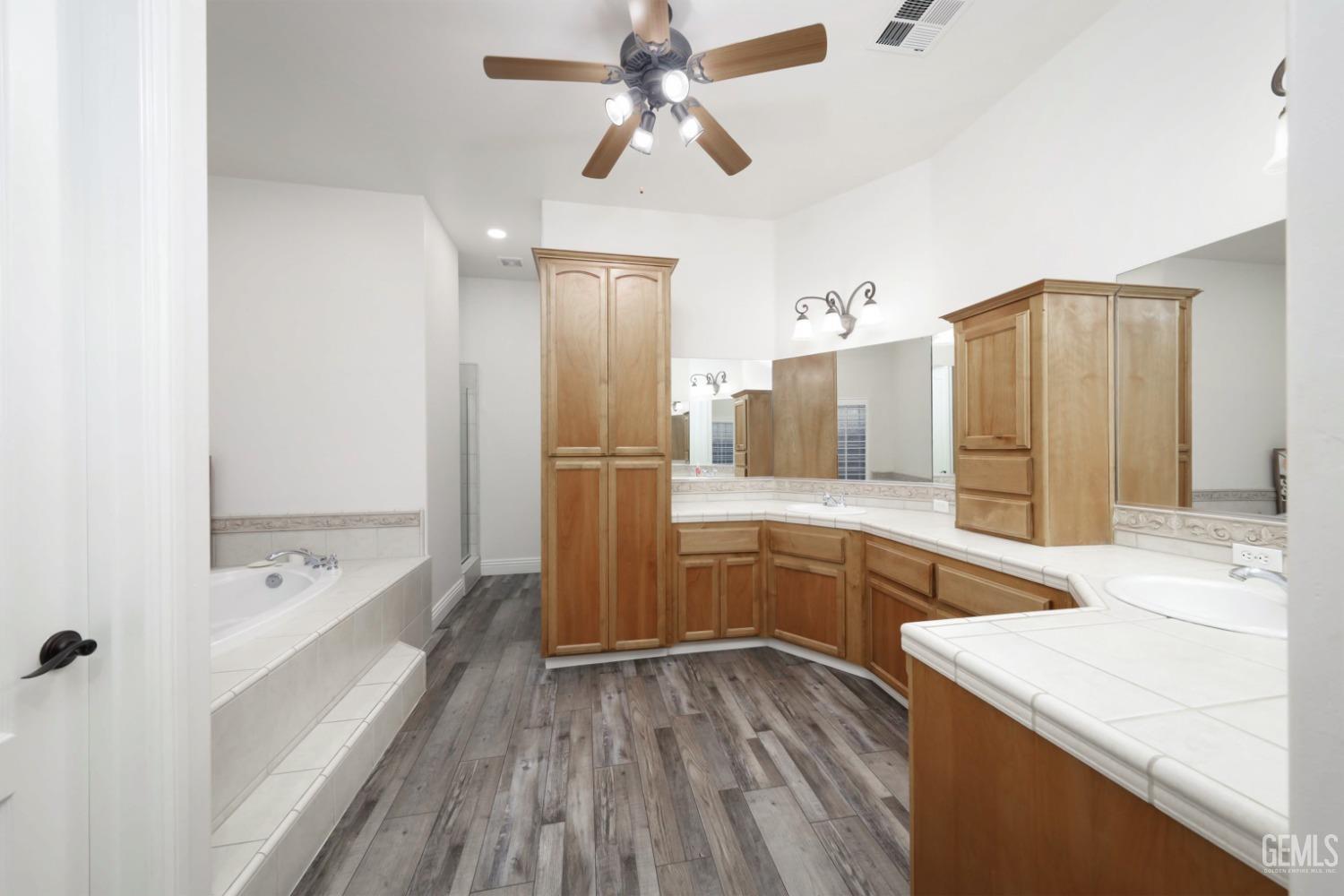 Undisclosed Address Bakersfield, CA 93312 - Photo 15 of 36 a bathroom with a sink a bathtub a mirror and a shower