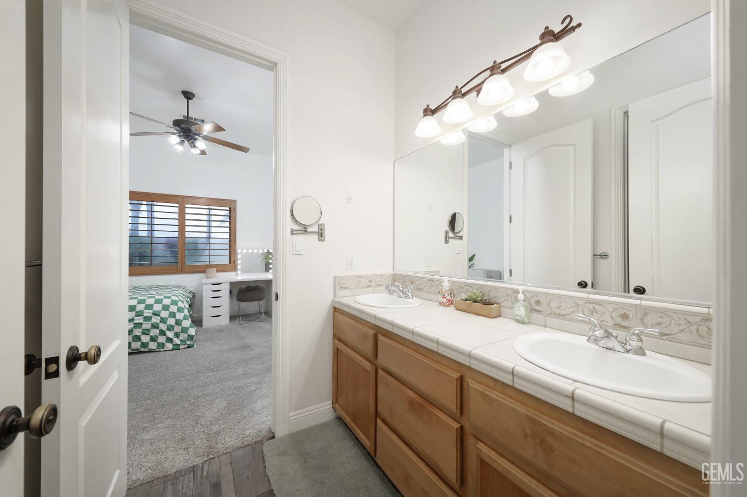 Undisclosed Address Bakersfield, CA 93312 - Photo 21 of 36 a spacious bathroom with a granite countertop sink a mirror and a