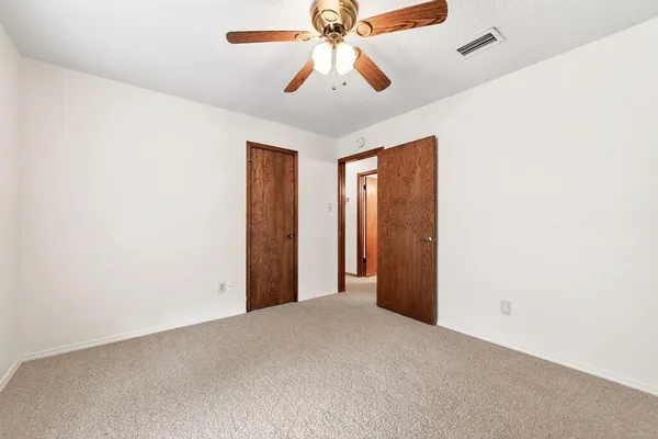 an empty room with chandelier fan
