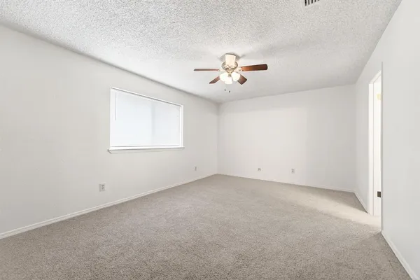 an empty room with a empty space and a ceiling fan
