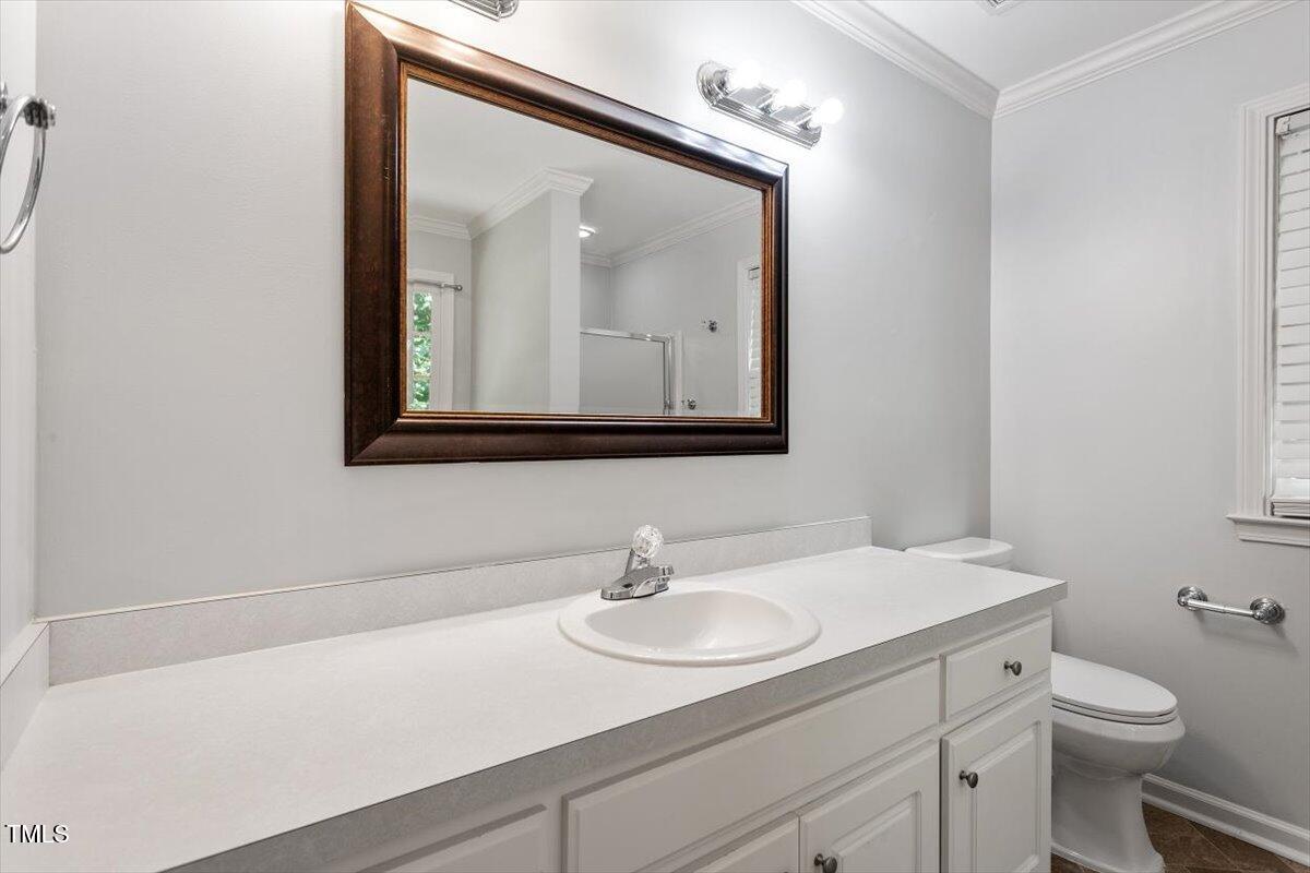 2474 Sumter Drive Garner, NC 27529 - Photo 16 of 27 a bathroom with a toilet a sink and mirror
