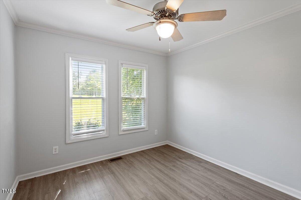 2474 Sumter Drive Garner, NC 27529 - Photo 19 of 27 an empty room with wooden floor fan and windows