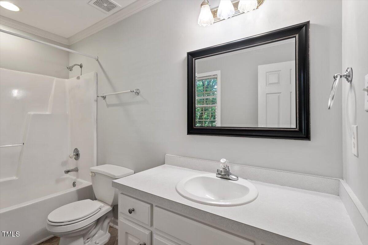 2474 Sumter Drive Garner, NC 27529 - Photo 20 of 27 a bathroom with a toilet a sink a mirror and a shower