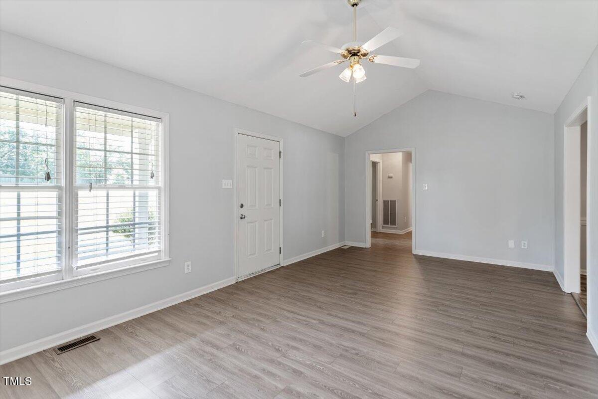 2474 Sumter Drive Garner, NC 27529 - Photo 6 of 27 an empty room with wooden floor ceiling fan and window