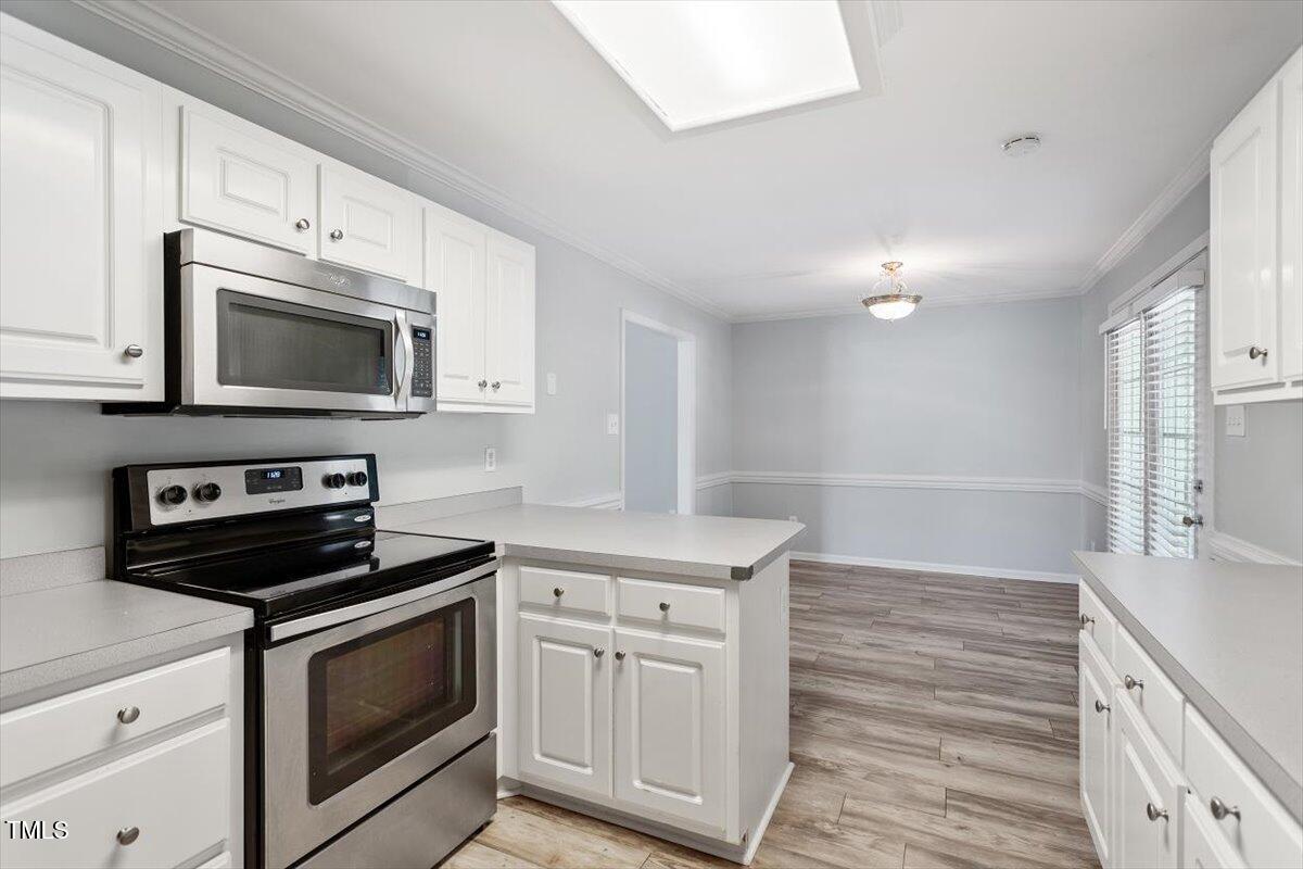 2474 Sumter Drive Garner, NC 27529 - Photo 9 of 27 a kitchen with white cabinets stainless steel appliances and sink